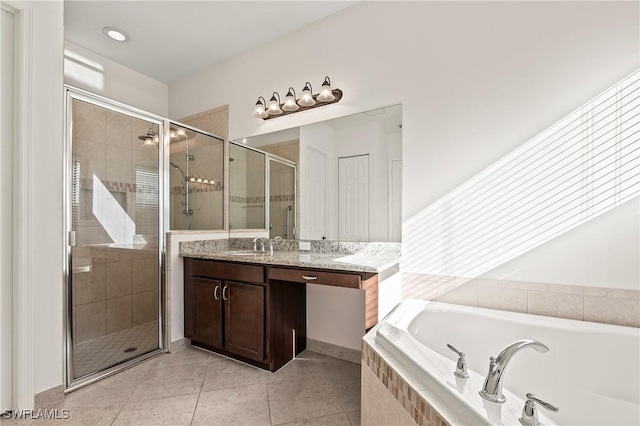 bathroom featuring tile patterned floors, vanity, and shower with separate bathtub