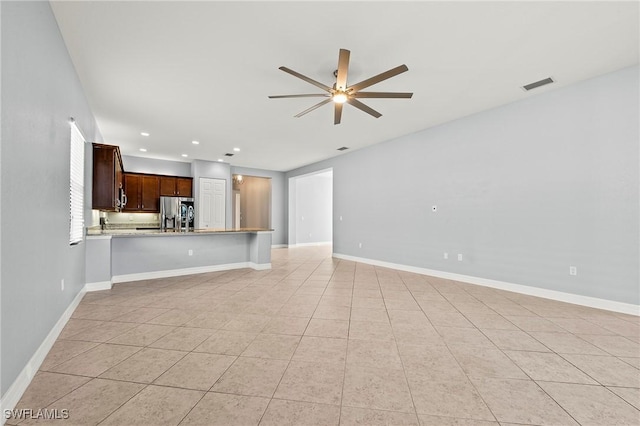 unfurnished living room featuring ceiling fan and light tile patterned floors