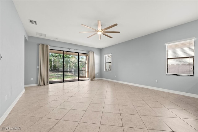 empty room with ceiling fan and light tile patterned floors