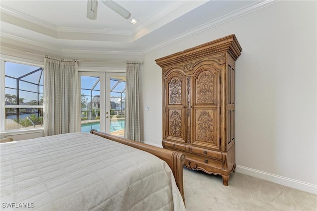 carpeted bedroom with french doors, access to outside, a tray ceiling, ceiling fan, and crown molding