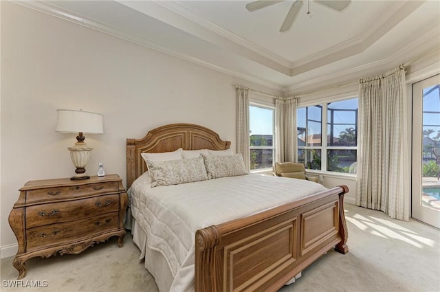 bedroom with light carpet, a tray ceiling, ceiling fan, and crown molding