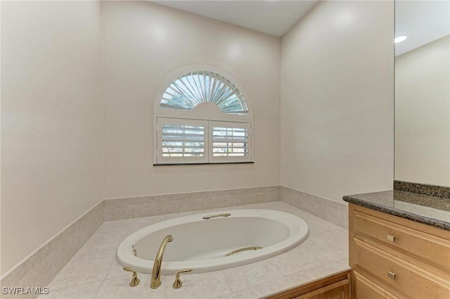 bathroom featuring vanity and tiled bath