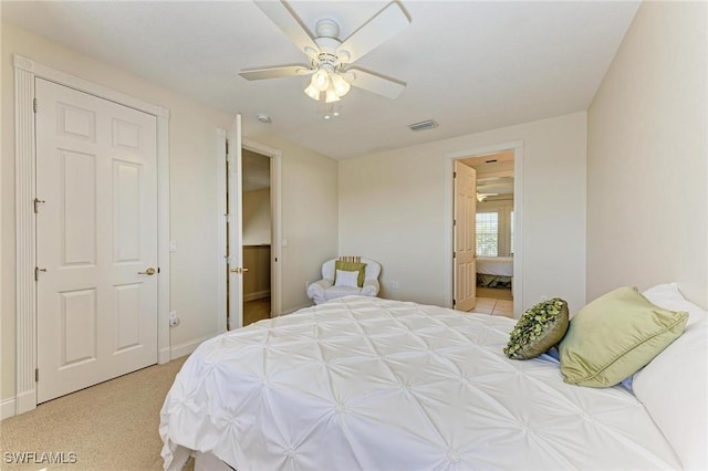 bedroom with connected bathroom, ceiling fan, and light carpet