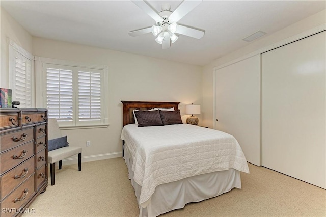 carpeted bedroom featuring ceiling fan and a closet