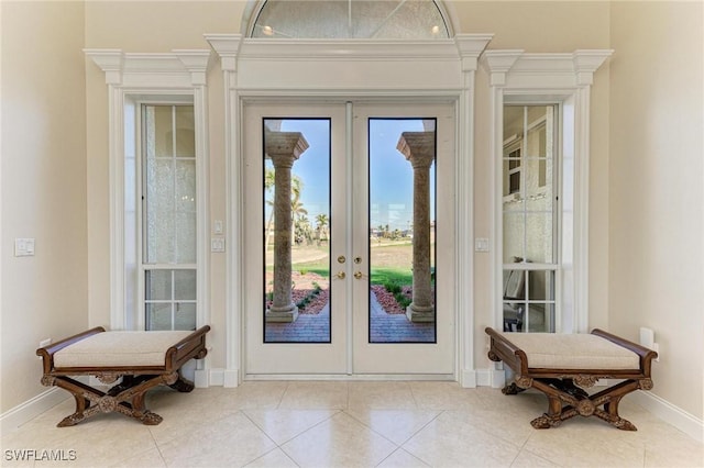 doorway to outside featuring french doors, light tile patterned floors, and ornamental molding