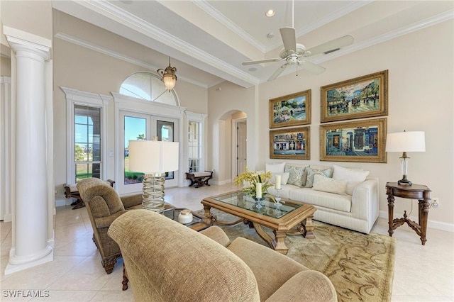 tiled living room featuring decorative columns, ceiling fan, and ornamental molding