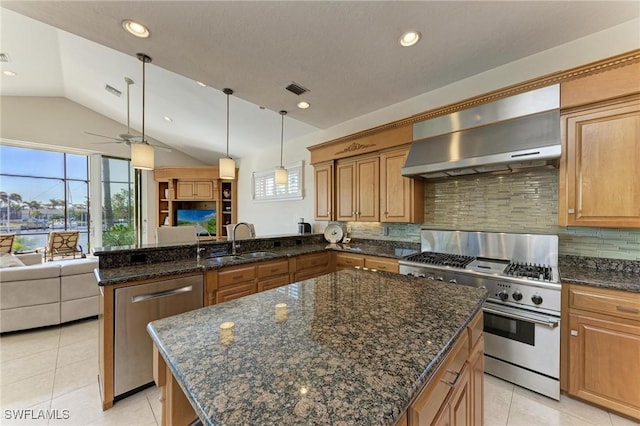 kitchen featuring appliances with stainless steel finishes, tasteful backsplash, sink, wall chimney range hood, and lofted ceiling