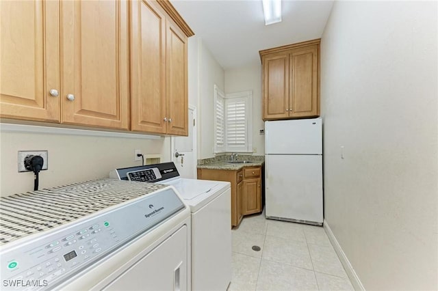 laundry room featuring washing machine and dryer, sink, light tile patterned floors, and cabinets