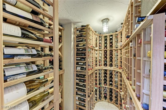 wine room featuring tile patterned floors and a textured ceiling