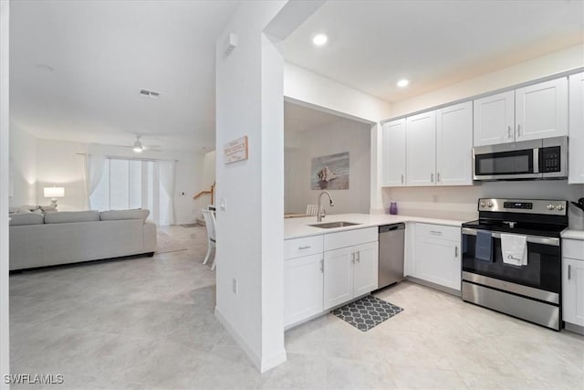 kitchen with stainless steel appliances, ceiling fan, white cabinets, and sink