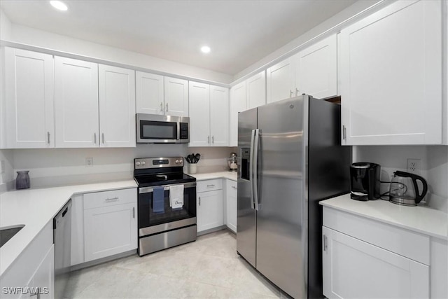 kitchen featuring white cabinets, appliances with stainless steel finishes, and light tile patterned floors