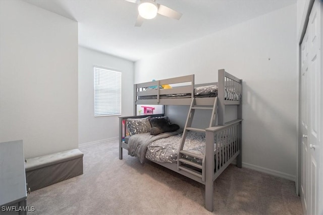 bedroom with a closet, ceiling fan, and light colored carpet