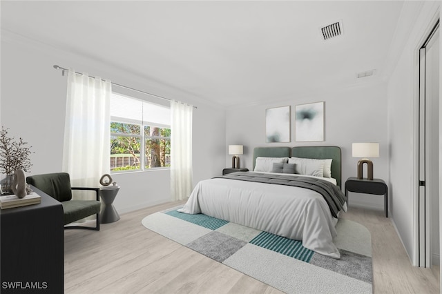 bedroom featuring visible vents, light wood-style flooring, and baseboards