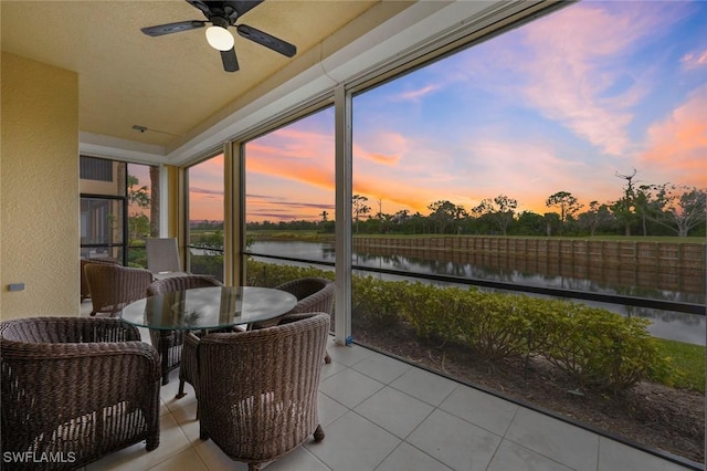 sunroom / solarium with a water view and ceiling fan