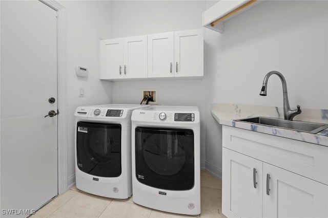 laundry room featuring sink, light tile patterned floors, cabinets, and washing machine and clothes dryer