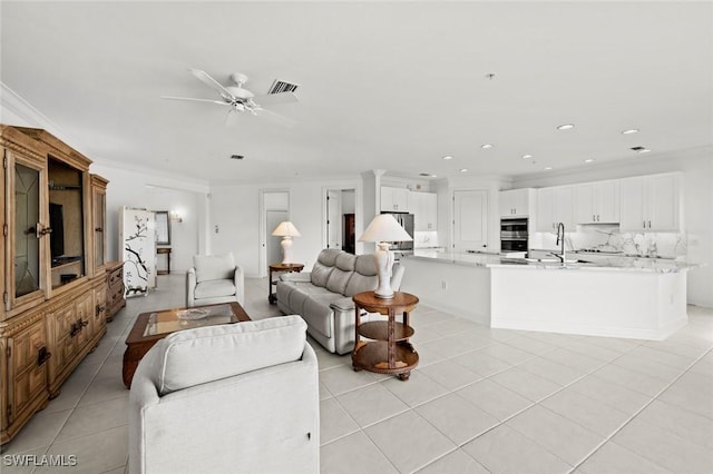 living area with light tile patterned flooring, recessed lighting, visible vents, a ceiling fan, and crown molding