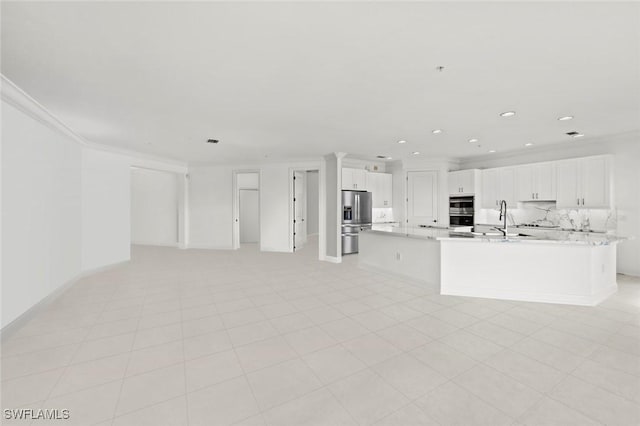 unfurnished living room featuring sink, ornamental molding, and light tile patterned flooring