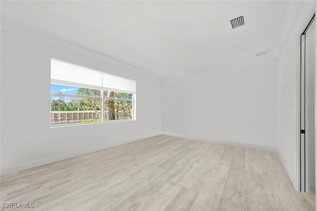 unfurnished room with light wood-style floors, baseboards, and visible vents