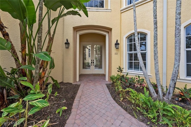 view of exterior entry featuring stucco siding and french doors