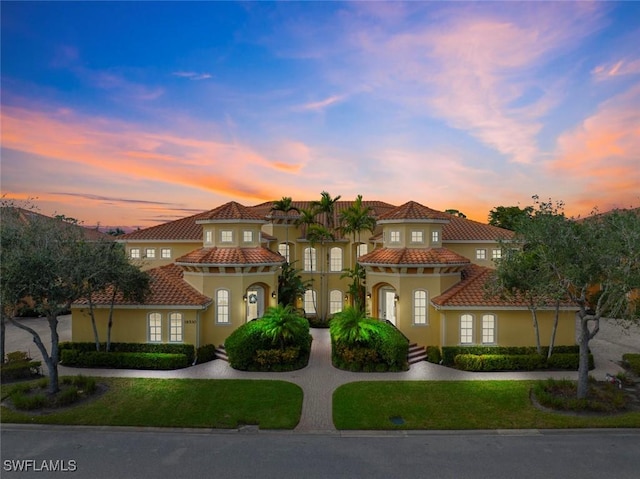 18530 Sandalwood Pointe Unit 101, Fort Myers, FL 33908 - mediterranean / spanish house with stucco siding, a tiled roof, and a yard