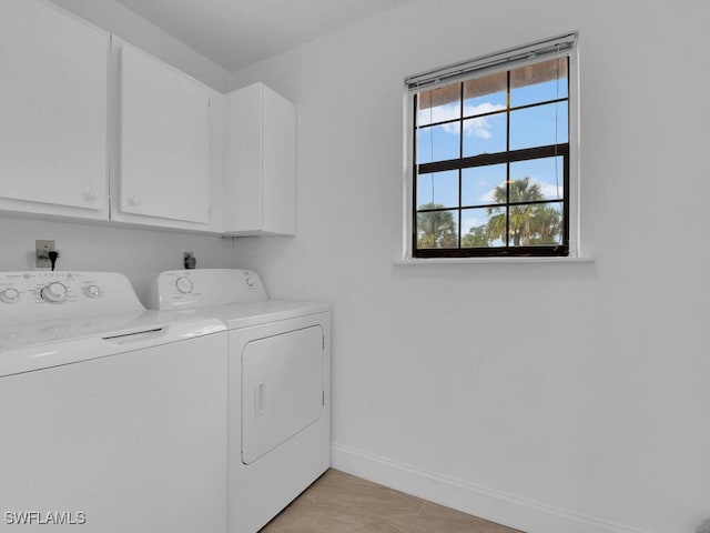 laundry room featuring washer and clothes dryer and cabinets