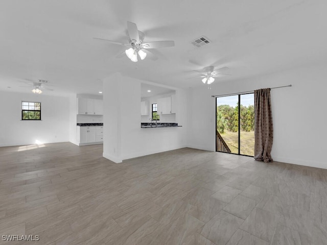 unfurnished living room featuring ceiling fan