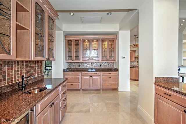 kitchen with sink, dark stone counters, and decorative backsplash