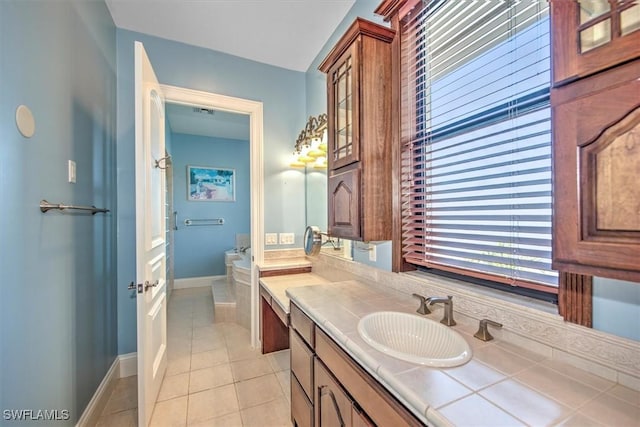 bathroom featuring vanity, tile patterned flooring, and a bath