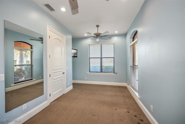 empty room with ceiling fan and light colored carpet