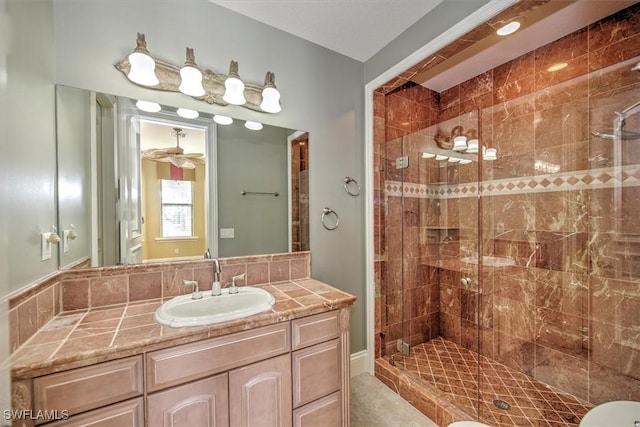 bathroom featuring ceiling fan, walk in shower, and vanity