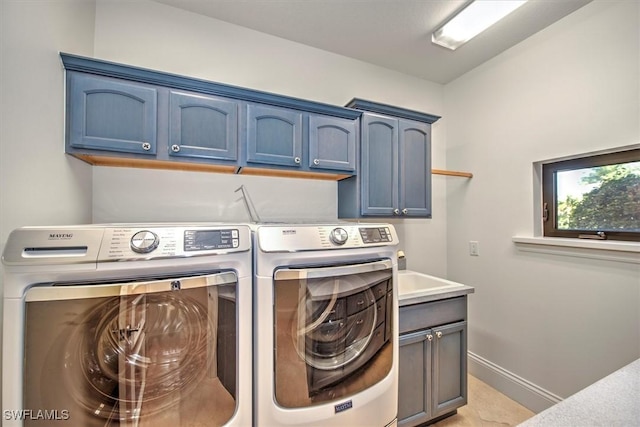 washroom featuring washing machine and clothes dryer and cabinets