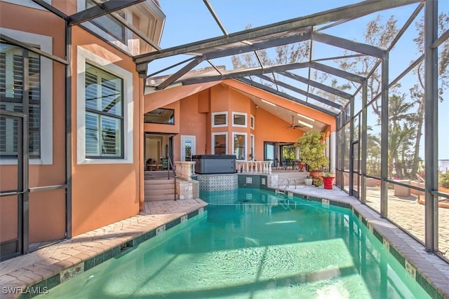 view of pool with ceiling fan, a jacuzzi, glass enclosure, and a patio area