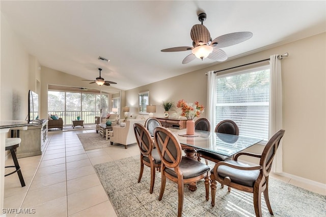 dining space featuring ceiling fan, a healthy amount of sunlight, light tile patterned floors, and lofted ceiling