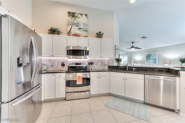 kitchen with sink, white cabinetry, dark stone counters, and stainless steel appliances