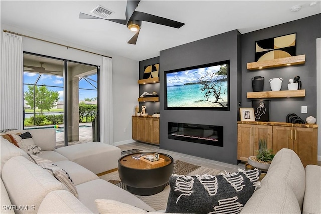 living room with ceiling fan and built in shelves