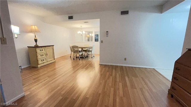 interior space with a notable chandelier and light hardwood / wood-style flooring