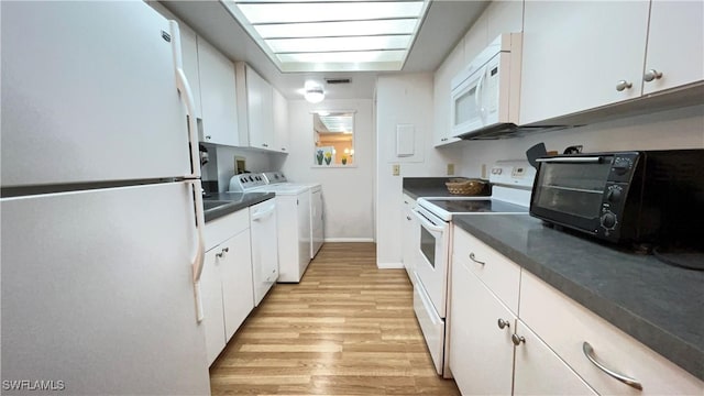 kitchen with white cabinets, light wood-type flooring, white appliances, and washing machine and dryer