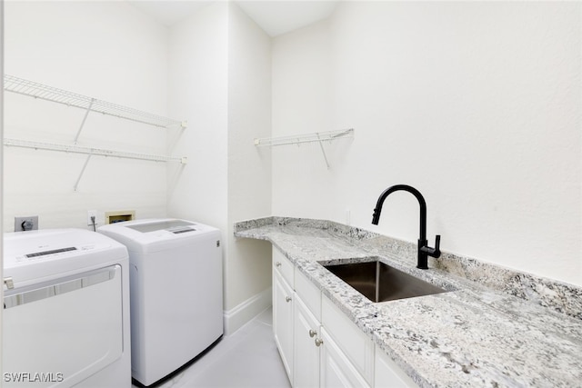 laundry room featuring cabinets, sink, and washer and clothes dryer