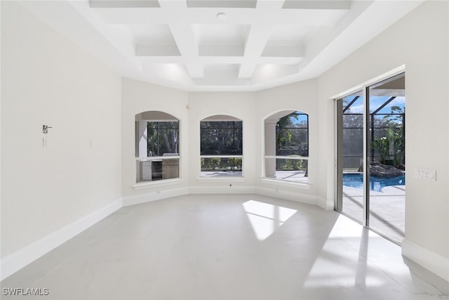 empty room featuring coffered ceiling and beam ceiling