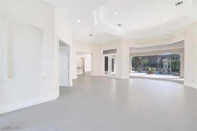 unfurnished living room with ornamental molding and a tray ceiling