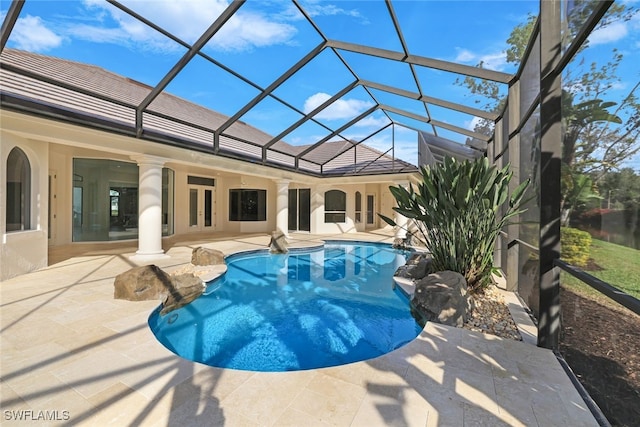 view of swimming pool with ceiling fan, a lanai, and a patio