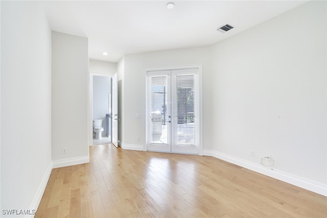 spare room with light wood-type flooring and french doors