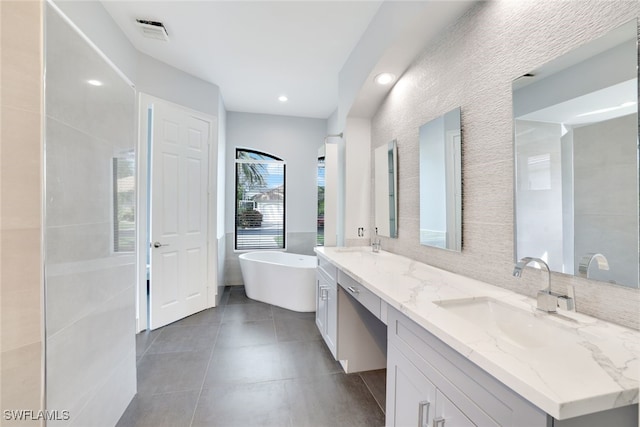 bathroom featuring a washtub, vanity, and tile patterned floors