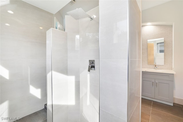 bathroom featuring tile patterned flooring, tile walls, vanity, a shower, and vaulted ceiling