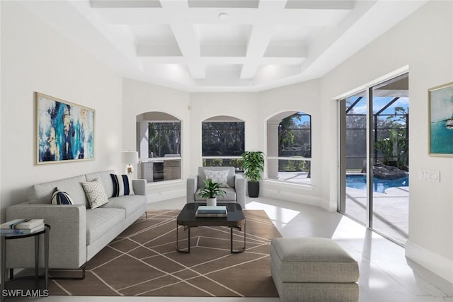 living room featuring coffered ceiling, beam ceiling, and a towering ceiling