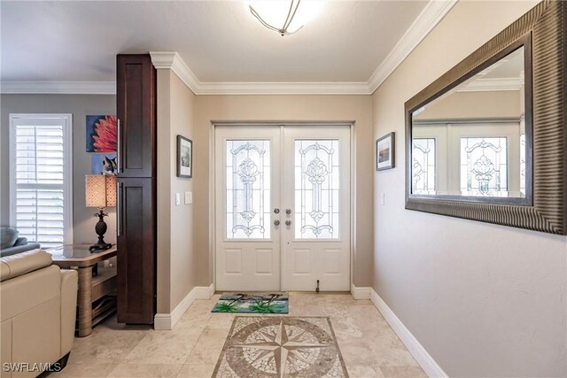 foyer entrance with ornamental molding, french doors, and baseboards