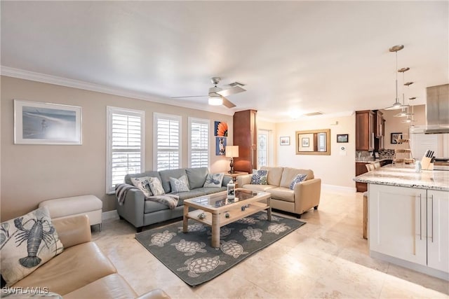 living room with ceiling fan, ornamental molding, and baseboards