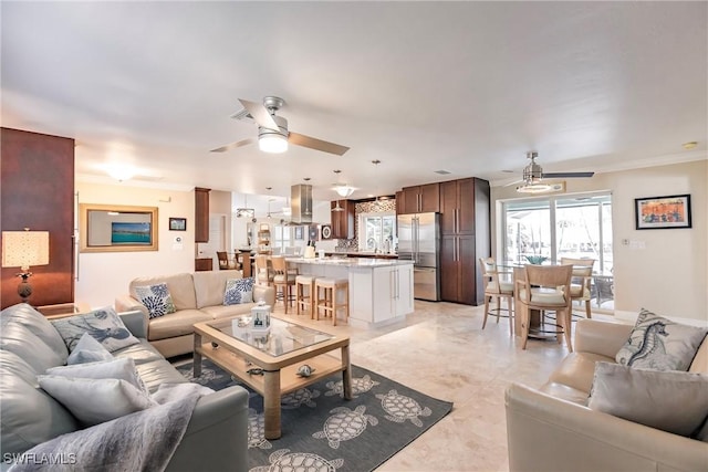 living area featuring a ceiling fan and crown molding