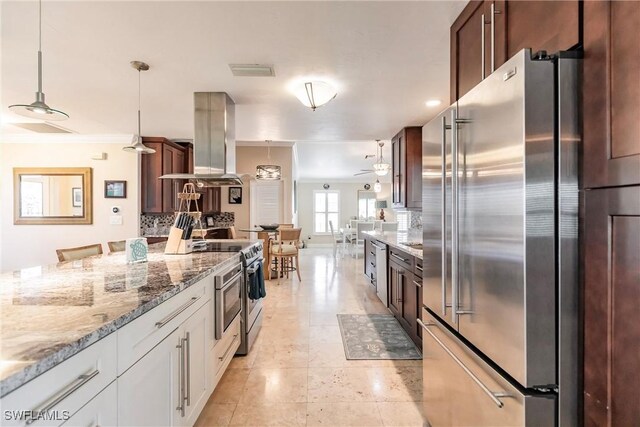 kitchen with white cabinetry, appliances with stainless steel finishes, light stone countertops, island exhaust hood, and pendant lighting