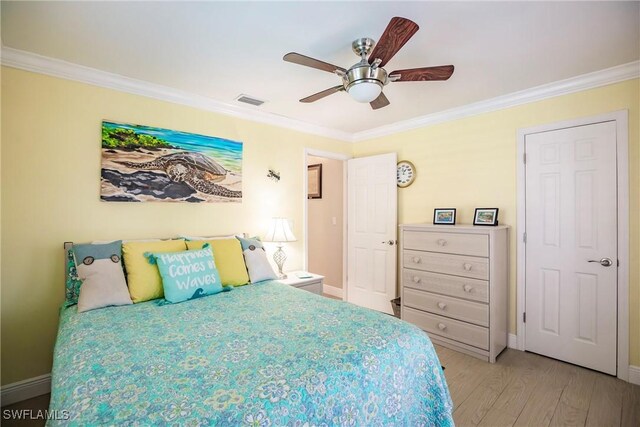 bedroom with ceiling fan, ornamental molding, and light wood-type flooring